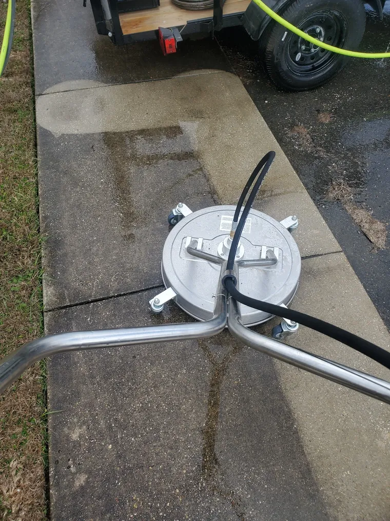 Delta Exterior Washing's surface-cleaner attachment on a wet driveway