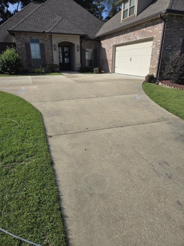 The concrete driveway at the brick home after washing