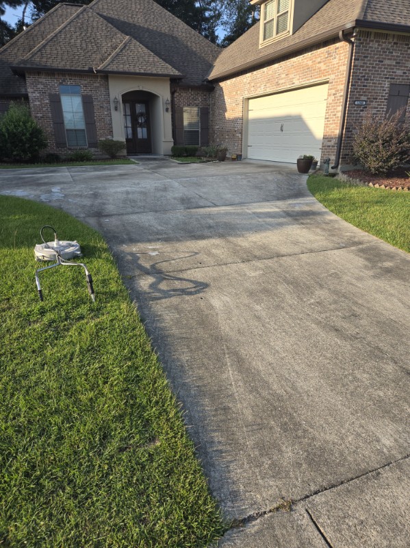 Concrete driveway at a brick home before washing