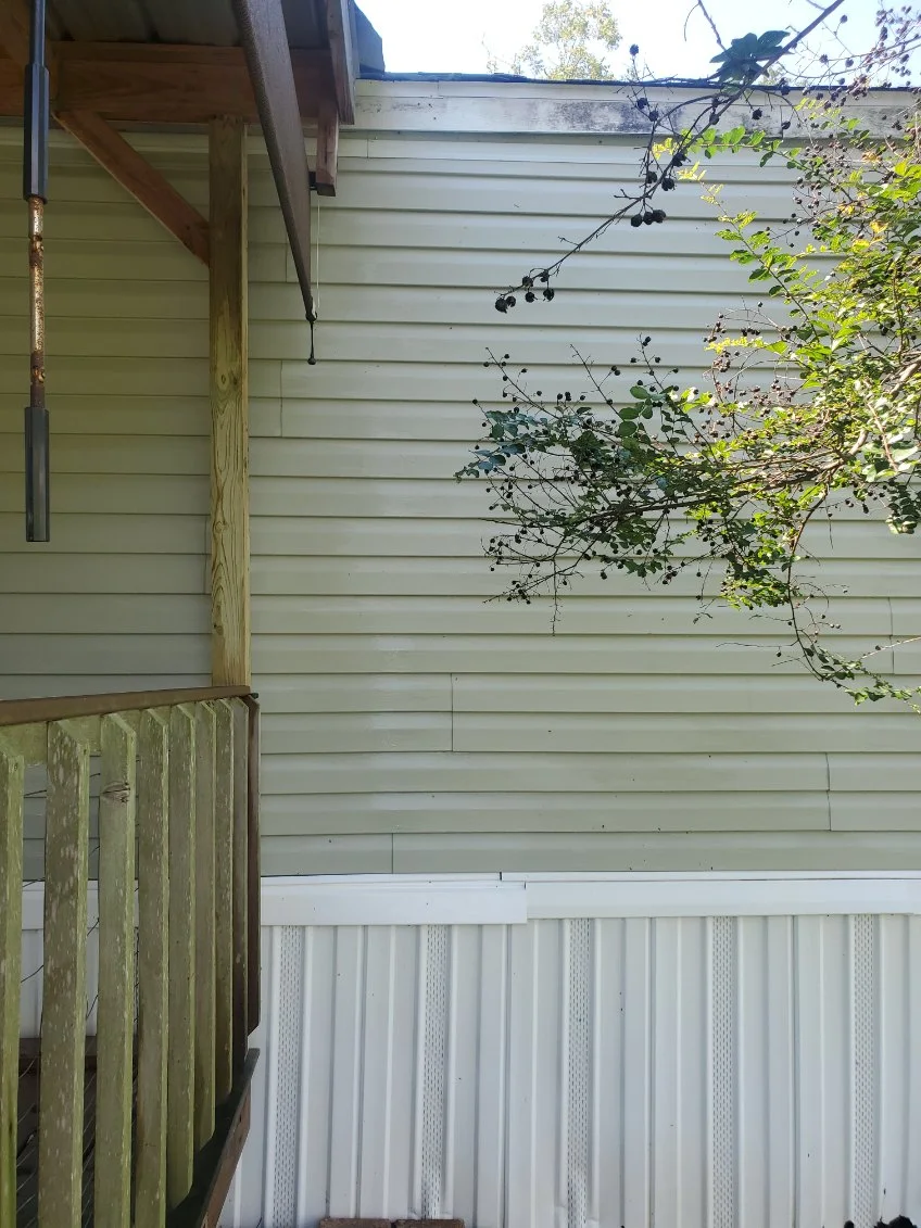 The same siding and wood rail after washing